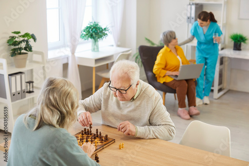 Quadro su tela Senior people in retirement home playing chess game, old age home nursing facili
