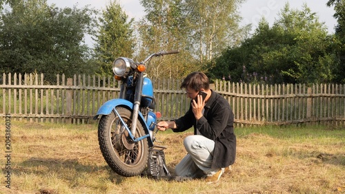 Fotografia Man finding himself in a difficult roadside situation, kneeling in a rural field