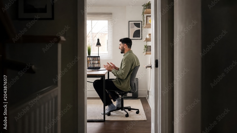 Fototapeta premium Generative AI, View Through Doorway of Man Having Multi Person Video Conference at Home