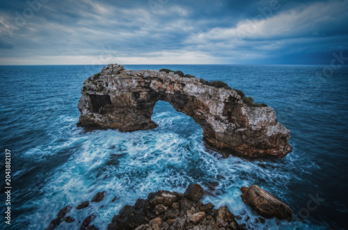 Bild auf Leinwand Natural arch formation on Mallorca Island observed at dusk, geological preservation, also known like Mirador de Es Pontas