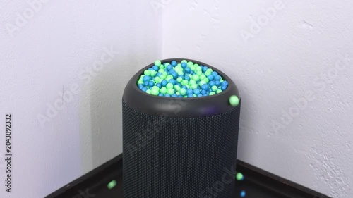 Small green and blue foam balls bouncing on a wireless smart speaker due to sound vibrations