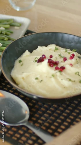 Vertical video: Panning camera revealing home table meal, showcasing salad, mash, bottles, chicken