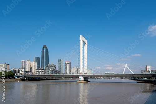 Modern Cable-stayed Bridge Over Urban River Under Clear Blue Sky