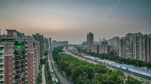 Urban residential skyline with roadway and rail line at dusk