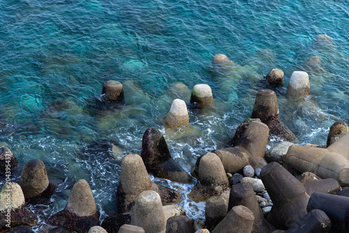 Ocean waves crashing against concrete tetrapods on the shore