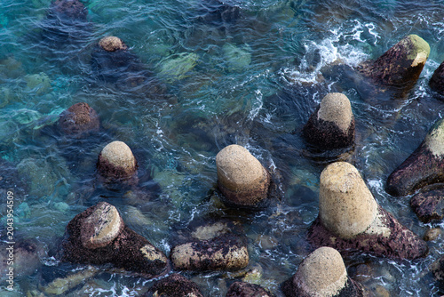 Top view of concrete tetrapods submerged in clear ocean water
