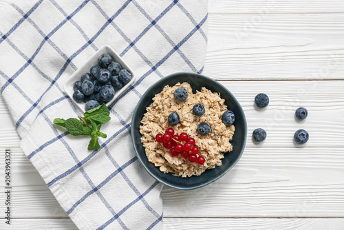 Bowl with tasty oatmeal and...