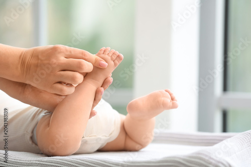 Mother massaging her baby's...