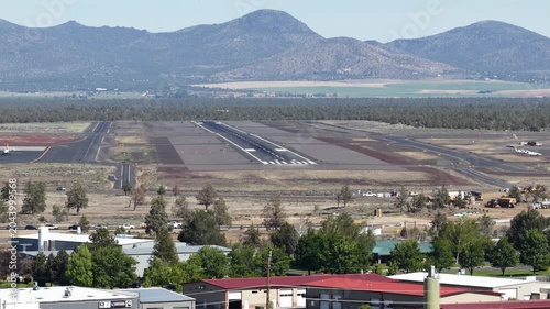 Aerial of plane taking off from Redmond Oregon Airport in spring on sunny day with mountain view of Cascades