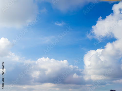 Blue sky with fluffy white clouds on a beautiful sunny day
