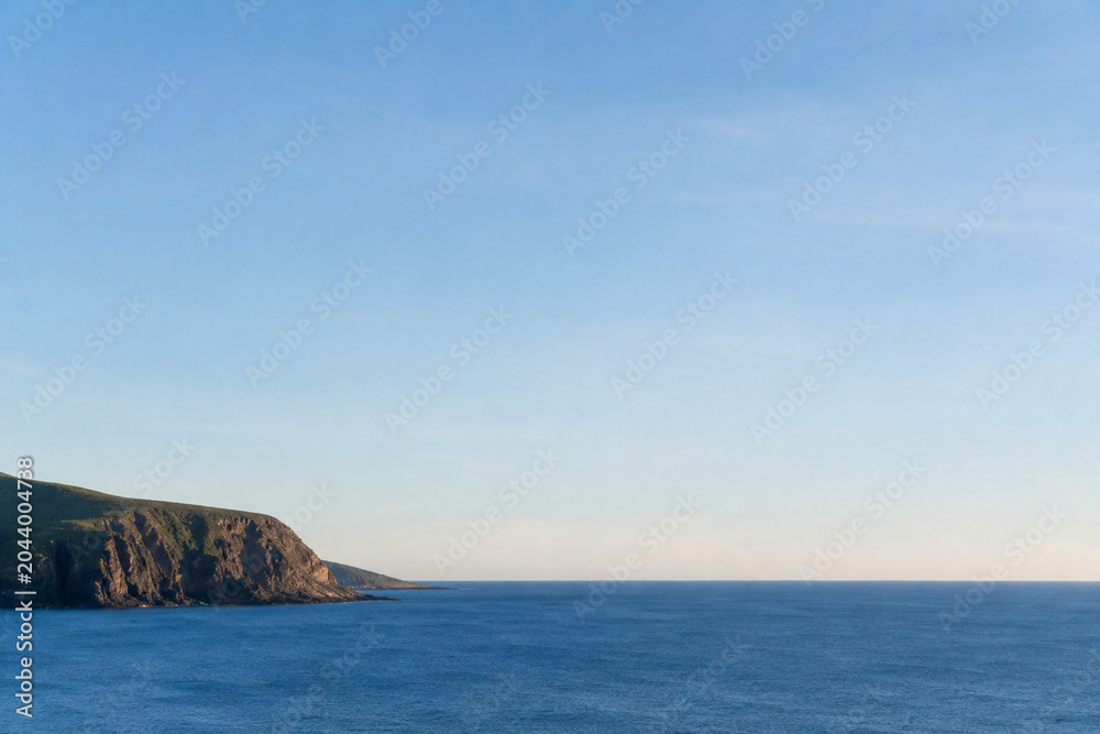 Naklejka premium Ultra Realistic Distant Coastal Cliff Meeting Calm Ocean Horizon