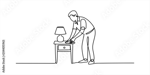 Photos Man cleaning a nightstand with a lamp