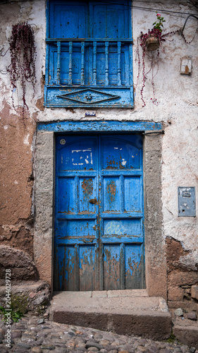Rustic blue wooden door and balcony on historic adobe building