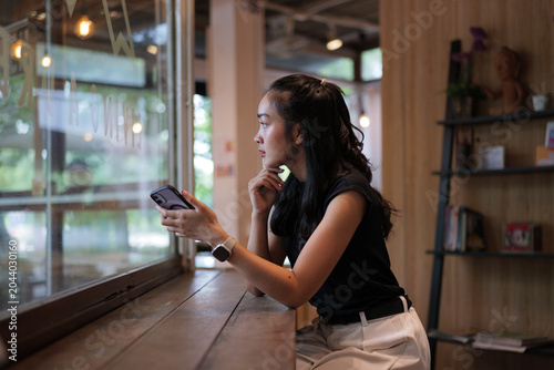 Young woman using smartphone relaxing in cafe