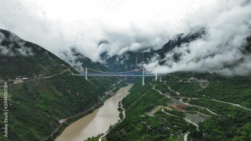 Suspension Bridge Over Misty Mountain River Valley