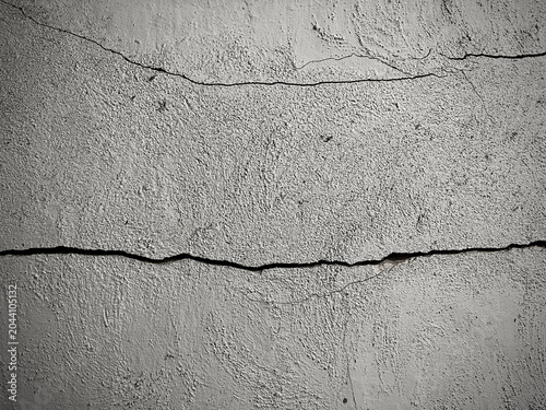 Black and white cracked wall texture with rough concrete surface