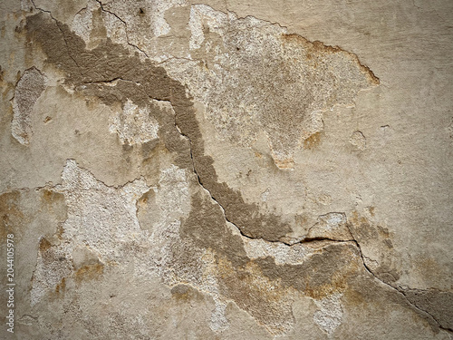 Weathered cracked concrete wall texture with peeling plaster