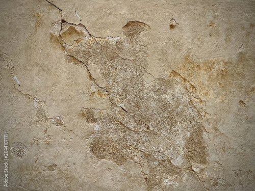 Cracked beige plaster wall texture with damaged vintage surface