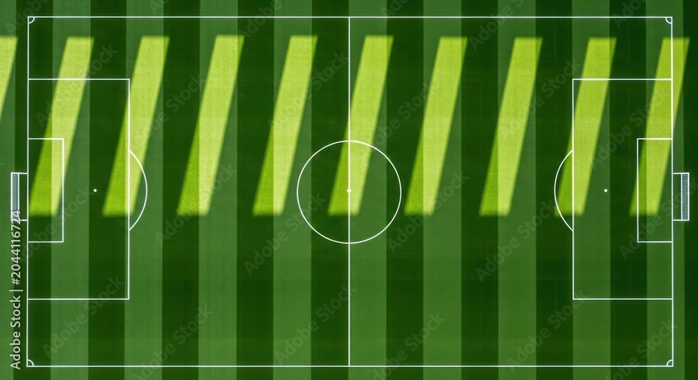 Obraz premium Aerial view of a soccer field with dramatic light and shadow stripes