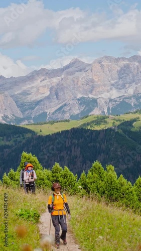 Timelapse middle-aged Asian group hikers hike trekking italian Dolomites mountain trail.Alpine meadow landscape jagged peaks limestone rocks summer adventure travel exploration outdoors activity guide