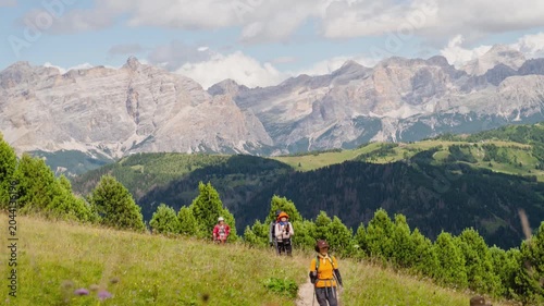 Timelapse middle-aged Asian group hikers hike trekking italian Dolomites mountain trail.Alpine meadow landscape jagged peaks limestone rocks summer adventure travel exploration outdoors activity guide