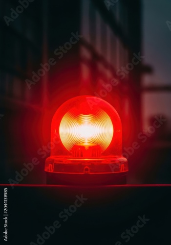 Red emergency warning light glowing in the dark