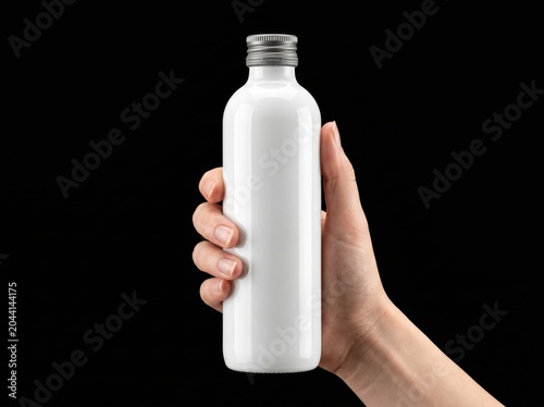 Blank white bottle mockup in hand against black background