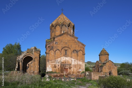 Historic brick church under a clear sky, surrounded by vegetation, cross-domed church, Marmashen Monastery, Marmashen Vank, Shirak Province, Armenia