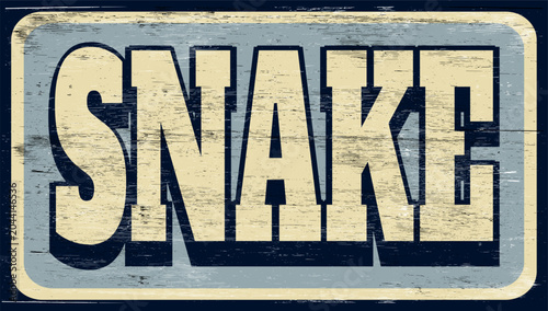 Aged and worn snake sign on wood