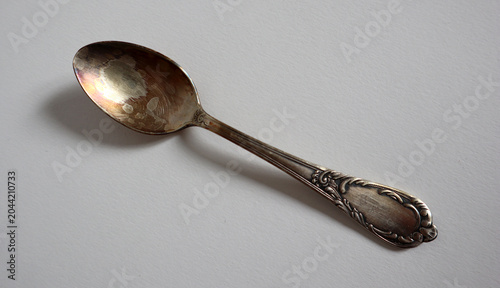 Photography A silver spoon rests on a flat white surface