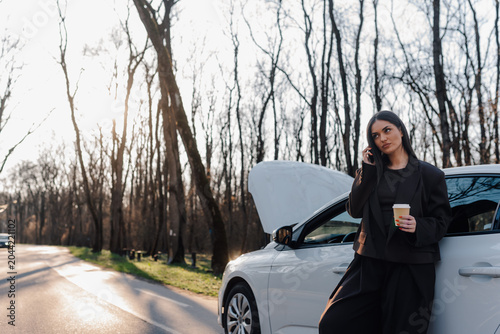 Bild auf Leinwand Woman calling for roadside assistance after car breakdown