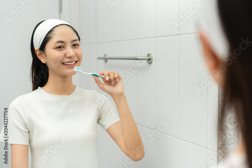 Fotografía Young smiling asian woman holding brush teeth for the health of teeth in restroom