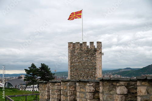 Foto Tower in Skopje showing the Macedonian flag on a cloudy day
