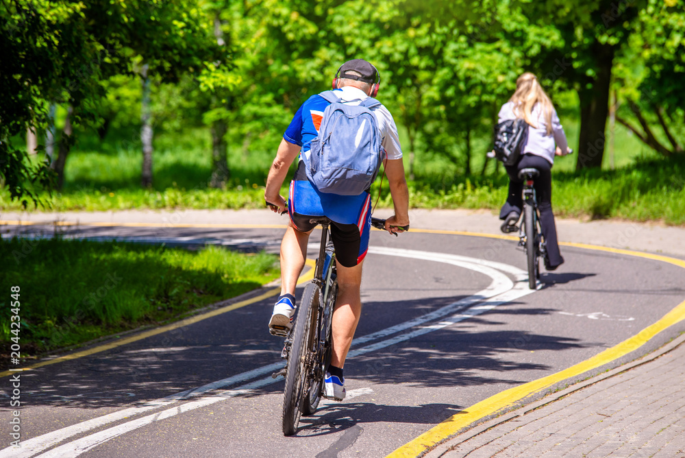 Fototapeta premium Cyclists ride on the bike path in the city Park 