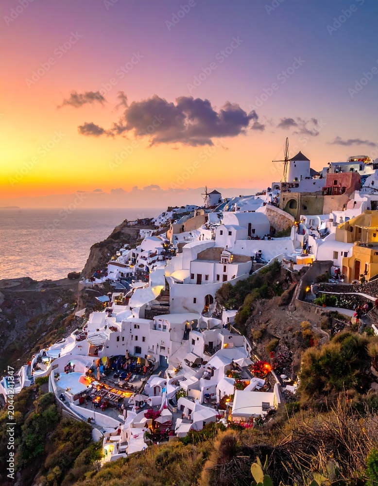 Fototapeta premium A picturesque Greek village perched on a cliffside at sunset, with white buildings, a windmill, and a vibrant sky