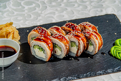 Fotografia Savoring the artful creation of sushi rolls on a stylish black slate plate