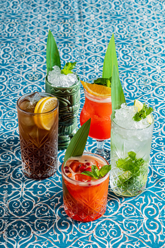 Colorful tropical drinks arranged beautifully on a vibrant blue patterned tablecloth