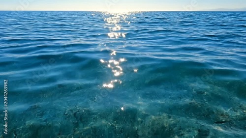 Sparkling blue sea ripples with bright sunlight reflection
