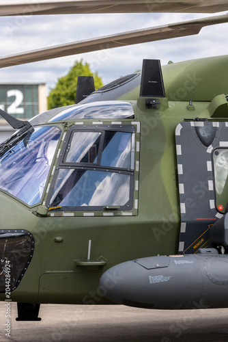 Φωτογραφία Closeup of military helicopter cockpit reflective windshield camouflage fuselage details