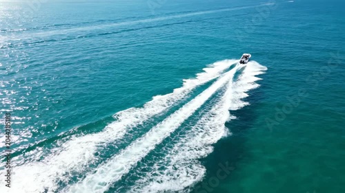 Aerial view of speedboat cruising through turquoise ocean water.