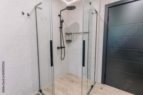 Canvas Print Modern glass shower enclosure with black fixtures and wooden floor in contempora