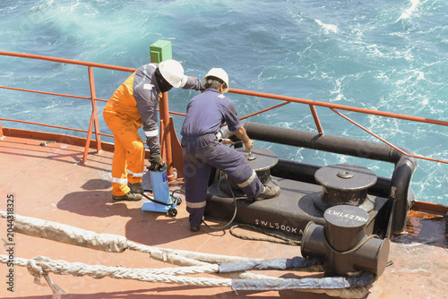 Cuadro en lienzo crew members performing maintenance work and greasing fairlead roller equipment