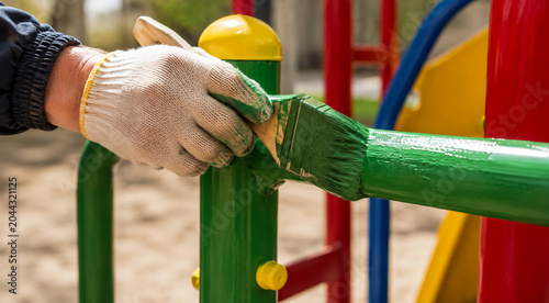 a person paints a playground with paints close-up, repair, empty space for text, template, photo background, layout, banner