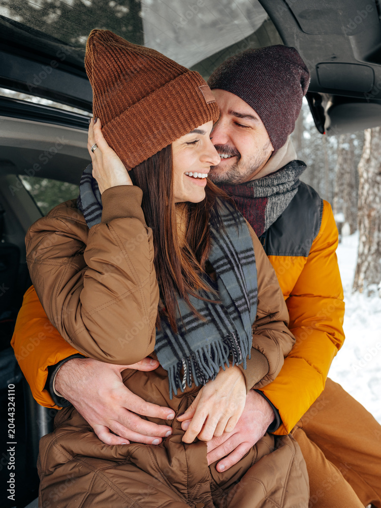 Fototapeta premium enjoys time together in snow covered forest during winter afternoon
