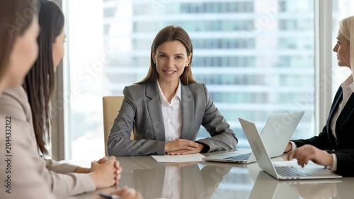Professional businesswoman leading a meeting in modern bright office.