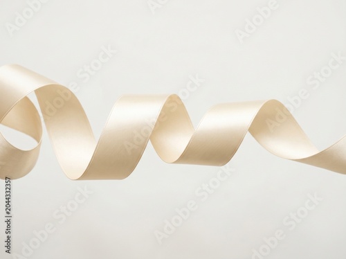 Elegant Cream Satin Ribbon Curled in Minimalist White Background