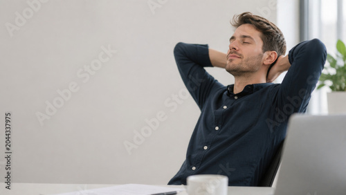 Relaxed man resting at office desk