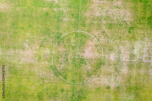 Schilderij op canvas Top down perspective of a patchy green and brown playing field The Concept of ou