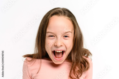 Schilderij op canvas Energetic young girl with an open mouth and playful surprised expression looking at the camera