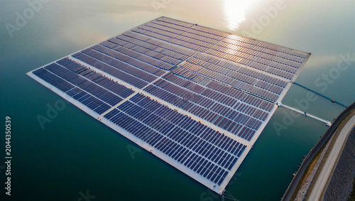 Foto Aerial view of a large floating solar panel array on a calm blue reservoir durin